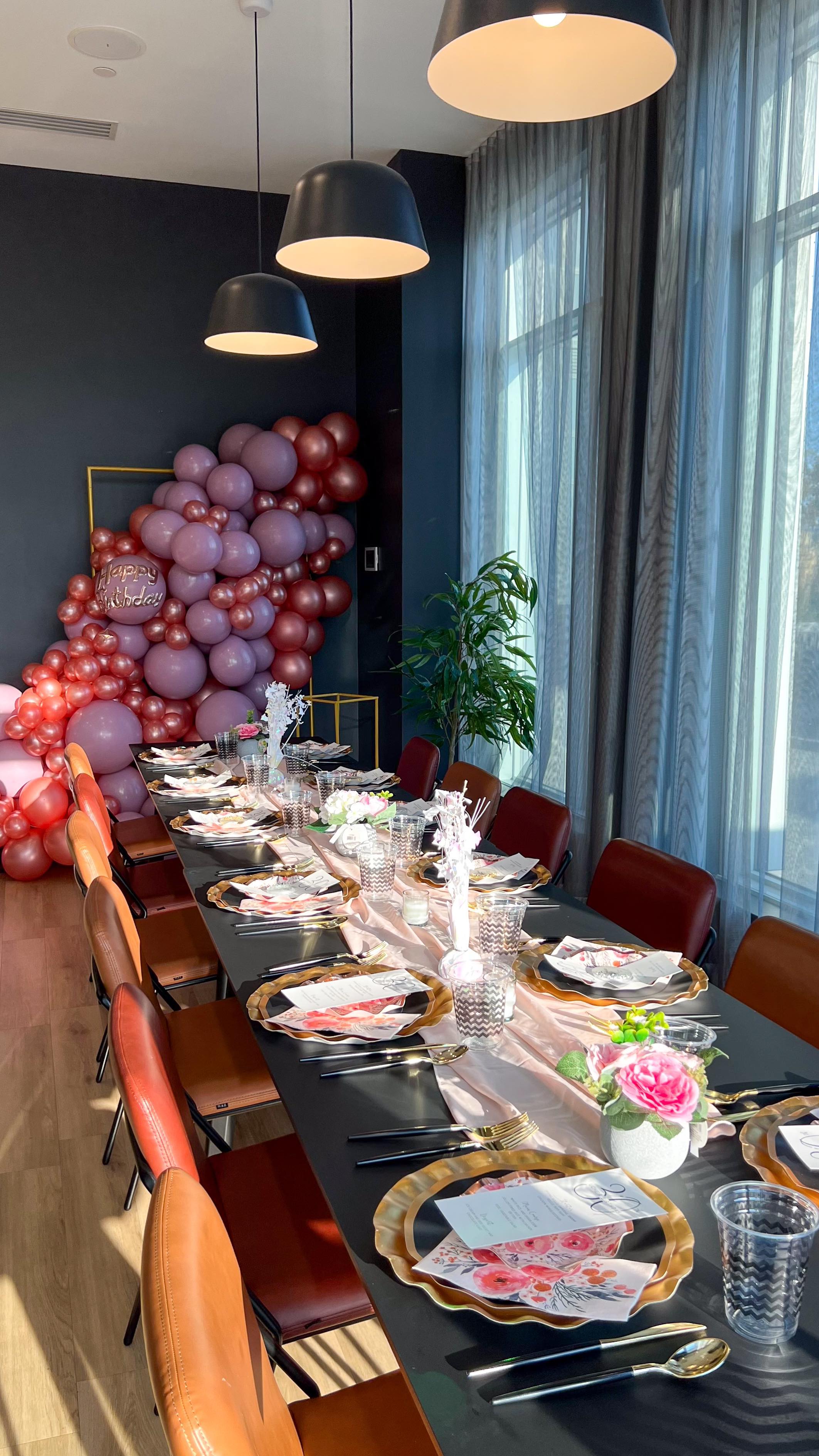 Black, red, and silver balloon installation surrounding illuminated number thirty marquee lights.